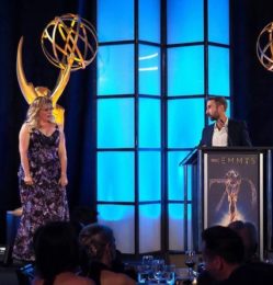 Kelvin Lawson – Director of Lisden Technology – on the podium at the Emmy Awards with host Kirsten Vangsness
